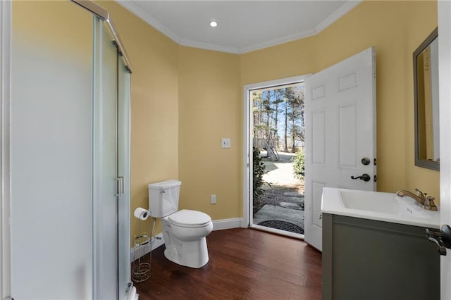 bathroom with toilet, vanity, hardwood / wood-style floors, crown molding, and an enclosed shower