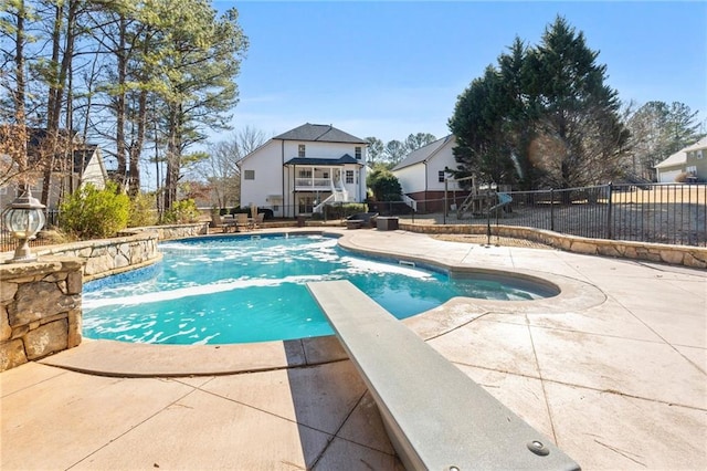 view of pool featuring a patio area, pool water feature, and a diving board