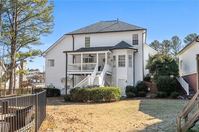 back of property featuring ceiling fan and a lawn