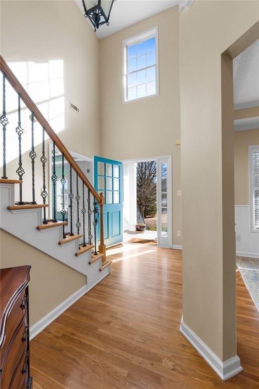 foyer entrance with a high ceiling and wood-type flooring