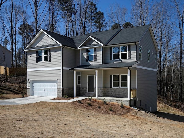 view of front of house with driveway, an attached garage, a porch, and brick siding