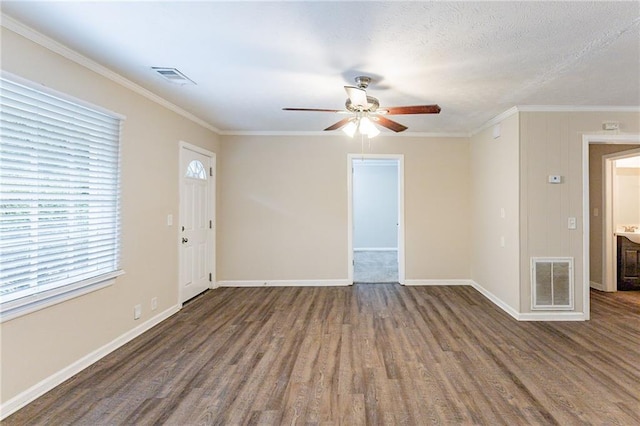 spare room with ceiling fan, dark hardwood / wood-style floors, a textured ceiling, and crown molding