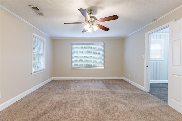 carpeted spare room with a wealth of natural light and crown molding