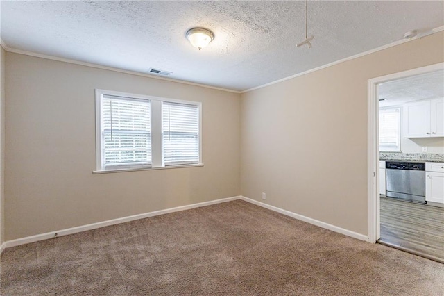 unfurnished room featuring carpet flooring, ornamental molding, and a textured ceiling