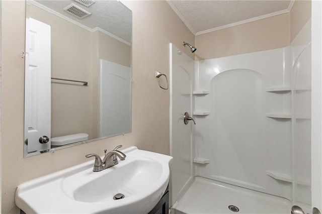 bathroom featuring toilet, a textured ceiling, crown molding, and a shower