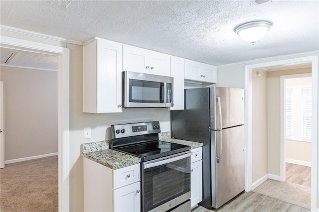 kitchen with white cabinetry, light stone countertops, appliances with stainless steel finishes, and light hardwood / wood-style flooring