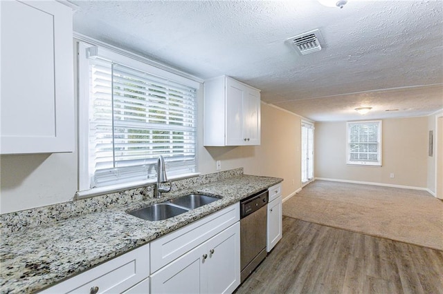 kitchen featuring a textured ceiling, sink, stainless steel dishwasher, white cabinetry, and light wood-type flooring