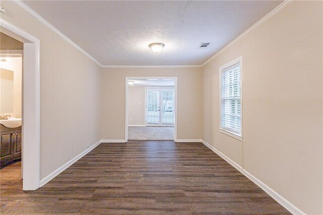 empty room featuring dark hardwood / wood-style flooring, a textured ceiling, sink, and crown molding