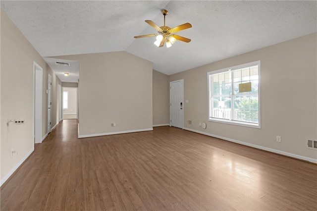 unfurnished living room with a textured ceiling, ceiling fan, hardwood / wood-style floors, and lofted ceiling