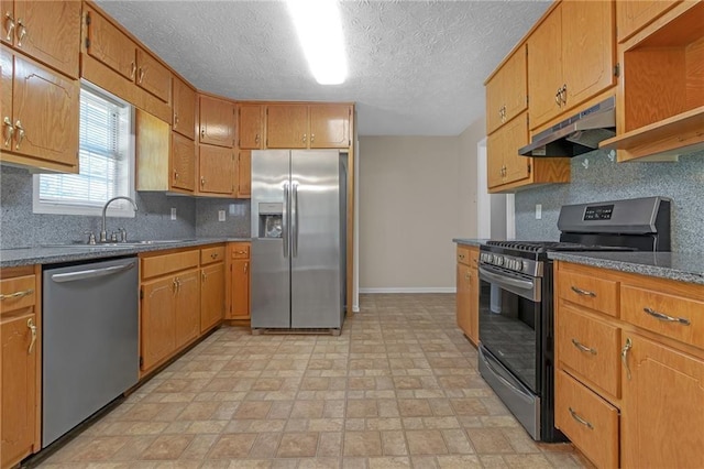 kitchen featuring a textured ceiling, stainless steel appliances, tasteful backsplash, and sink