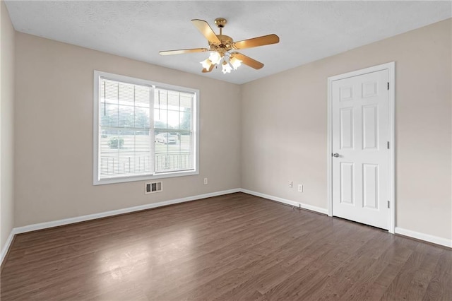 empty room featuring ceiling fan and dark wood-type flooring