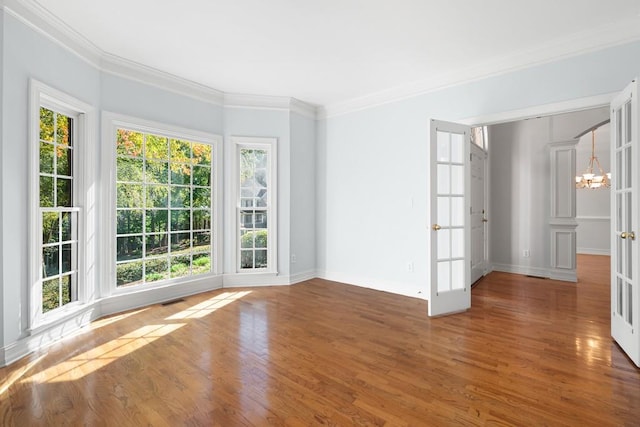 empty room with ornamental molding, a healthy amount of sunlight, and dark hardwood / wood-style flooring