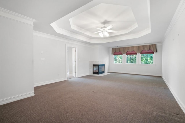 unfurnished living room with dark colored carpet, a multi sided fireplace, ornamental molding, and ceiling fan