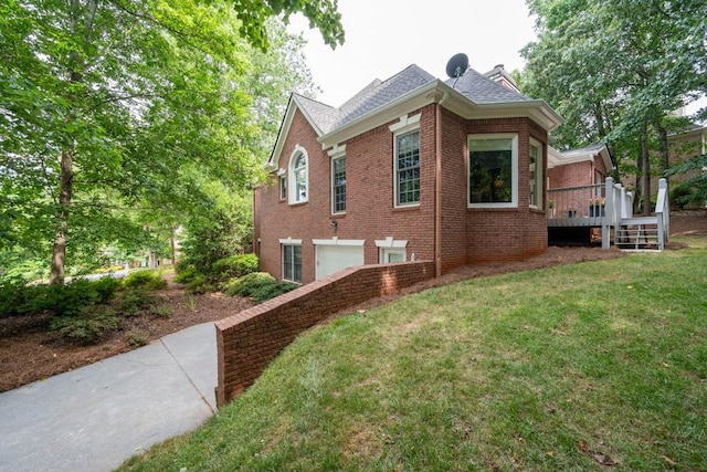 view of side of property with a deck, a yard, and a garage