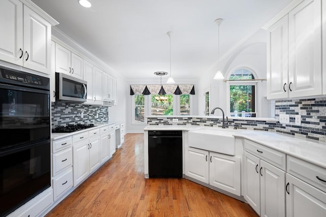 kitchen with black appliances, white cabinetry, and light wood-type flooring