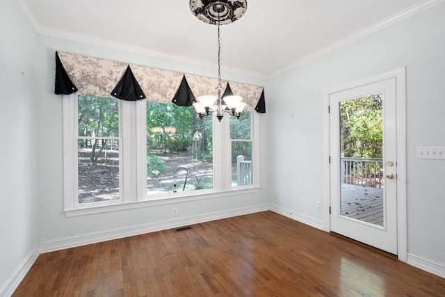 unfurnished dining area featuring a notable chandelier, hardwood / wood-style flooring, and ornamental molding