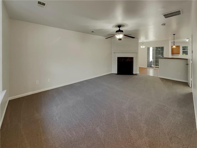 unfurnished living room with ceiling fan and carpet