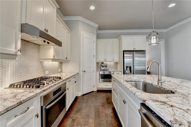 kitchen featuring appliances with stainless steel finishes, a sink, white cabinetry, under cabinet range hood, and ornamental molding