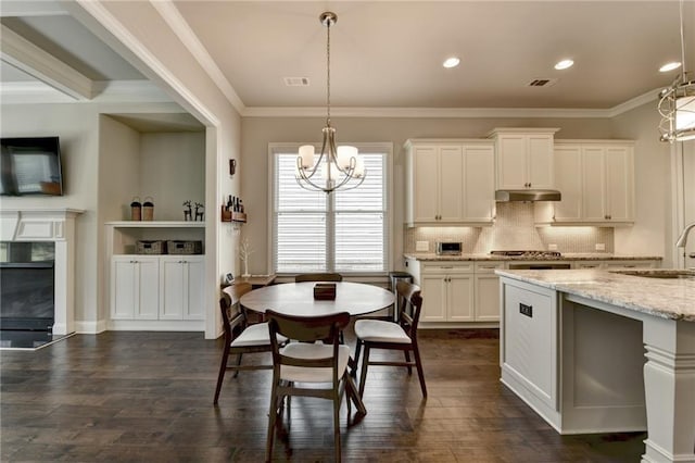 kitchen featuring an inviting chandelier, a sink, decorative backsplash, dark wood-type flooring, and visible vents