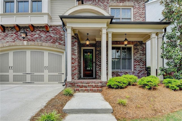 property entrance with a porch, brick siding, and driveway