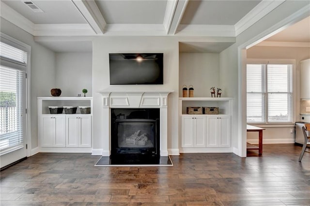 living area with dark wood-style flooring, visible vents, a fireplace with flush hearth, beam ceiling, and ornamental molding