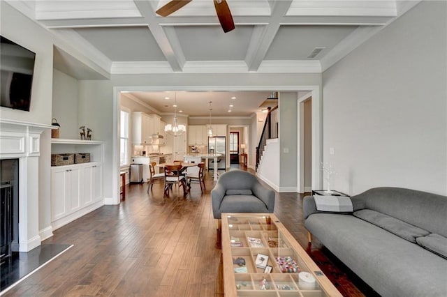 living area featuring plenty of natural light, stairs, beam ceiling, and a fireplace