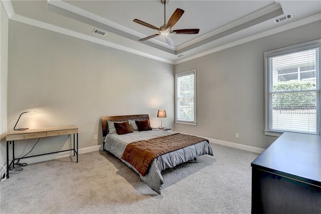 carpeted bedroom with crown molding, a raised ceiling, baseboards, and visible vents