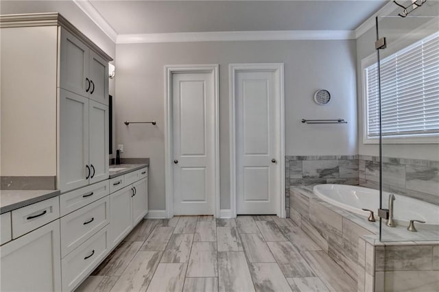 full bath featuring crown molding, a garden tub, and vanity