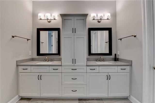 full bathroom with double vanity, baseboards, and a sink
