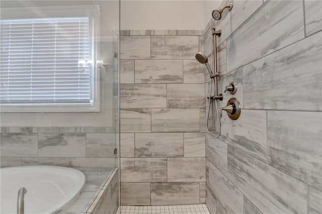 bathroom featuring a tile shower and a bath