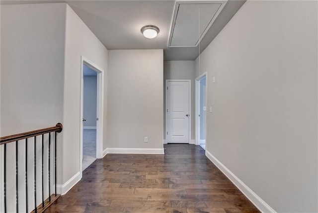 interior space featuring baseboards, attic access, and dark wood-type flooring