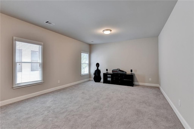 carpeted spare room with baseboards and visible vents