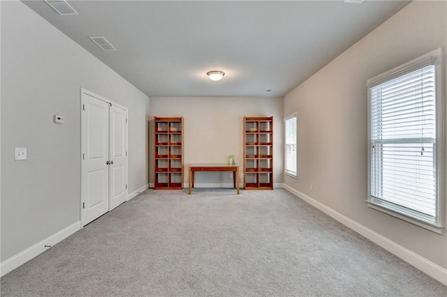 carpeted empty room with visible vents and baseboards