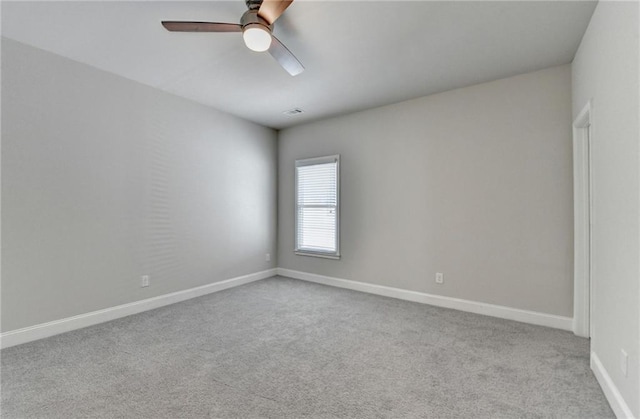 empty room featuring baseboards, carpet flooring, ceiling fan, and visible vents