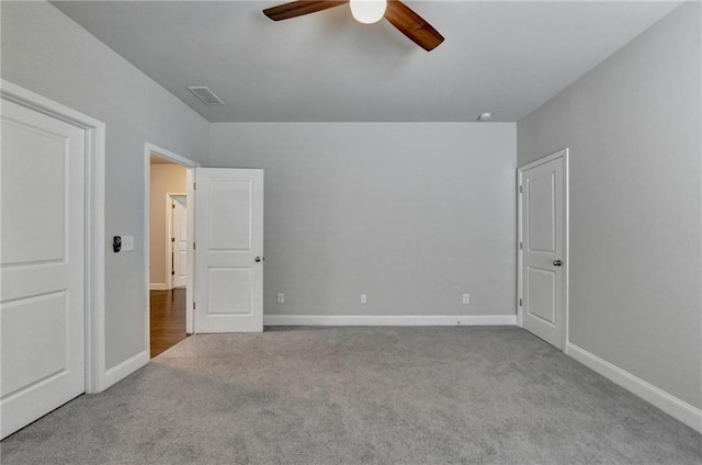 unfurnished bedroom with carpet floors, a ceiling fan, baseboards, and visible vents