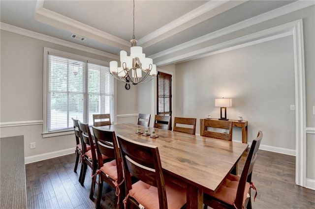 dining space with visible vents, dark wood-style floors, an inviting chandelier, and a raised ceiling