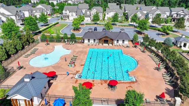 community pool featuring a residential view, fence, and a patio area