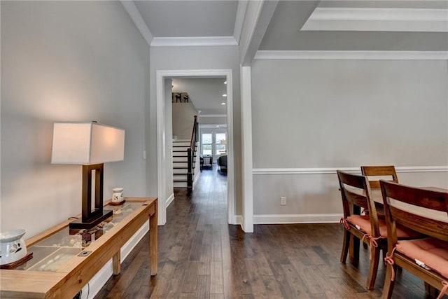 corridor featuring stairs, baseboards, dark wood finished floors, and ornamental molding