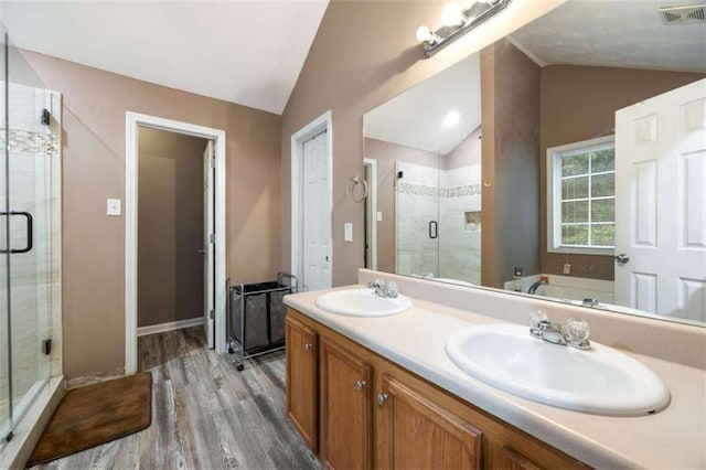 4424 English Loop, Stonecrest, GA 30038 - bathroom featuring lofted ceiling, wood finished floors, a stall shower, double vanity, and a garden tub