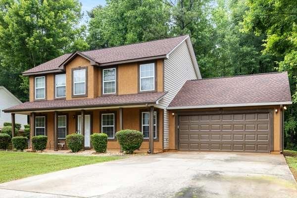 4424 English Loop, Stonecrest, GA 30038 - view of front of house featuring an attached garage, driveway, a porch, and a front yard