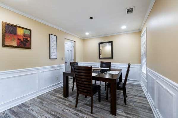 4424 English Loop, Stonecrest, GA 30038 - dining area featuring wood finished floors, a decorative wall, crown molding, and wainscoting