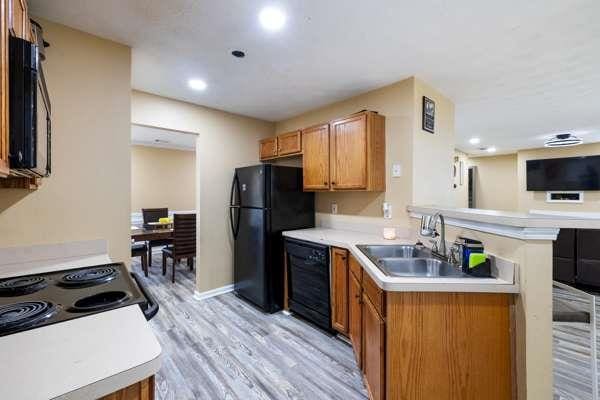 4424 English Loop, Stonecrest, GA 30038 - kitchen with black appliances, a sink, light countertops, light wood finished floors, and a peninsula