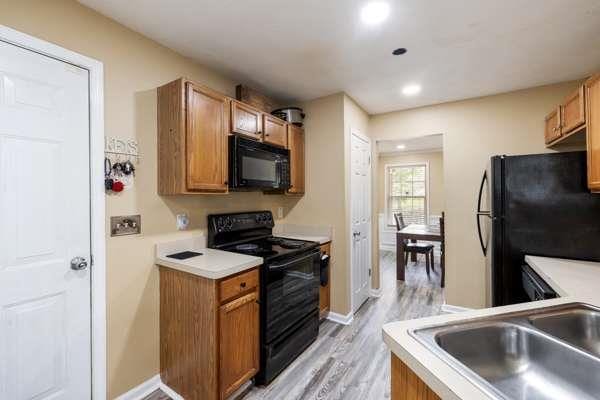 4424 English Loop, Stonecrest, GA 30038 - kitchen featuring black appliances, light wood-style flooring, light countertops, recessed lighting, and brown cabinets