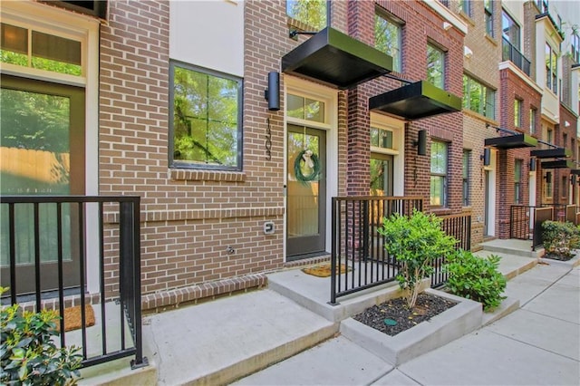 doorway to property featuring brick siding