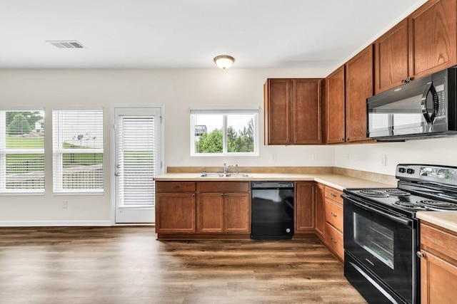 1530 Avalon Creek Rd, Sugar Hill, GA 30518 - kitchen featuring black appliances, a sink, dark wood-style flooring, and light countertops