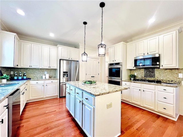 kitchen with white cabinetry, hanging light fixtures, a center island, stainless steel appliances, and light stone countertops