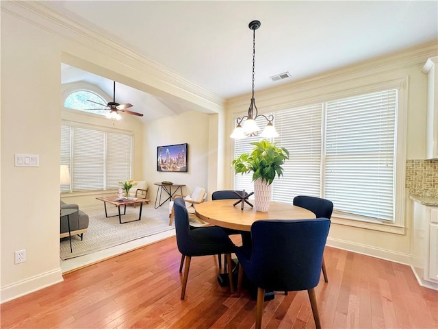 dining area featuring lofted ceiling, light hardwood / wood-style flooring, ornamental molding, and ceiling fan