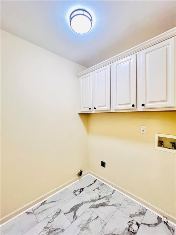 clothes washing area featuring cabinets, washer hookup, and electric dryer hookup