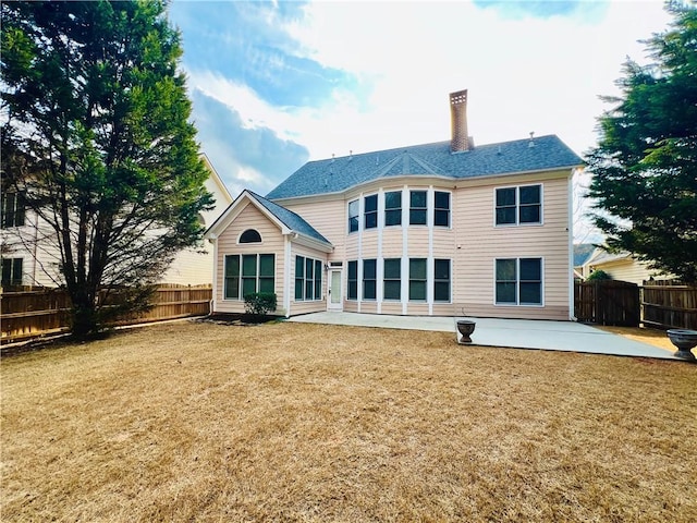 rear view of house featuring a patio area and a lawn