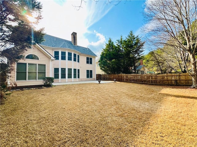 back of property with a patio area and a lawn